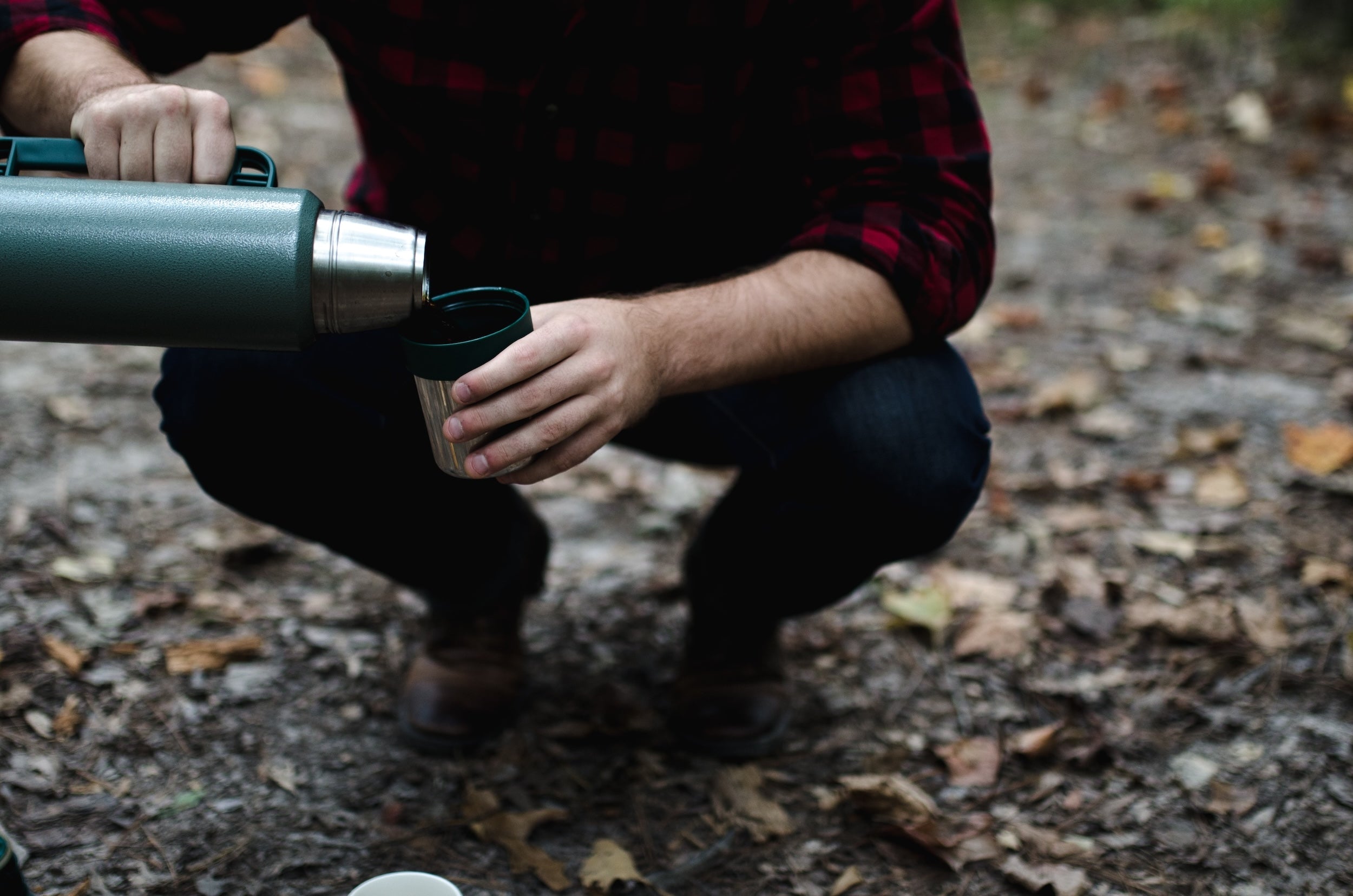 man pouring camp coffee from a thermos